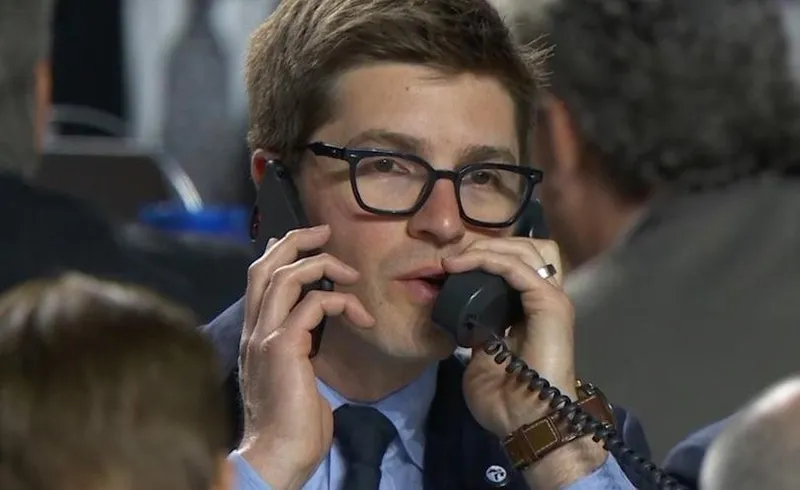 man answering two phones